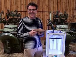 John van de Laar laat de eerste klomp uit de 3D-printer zien