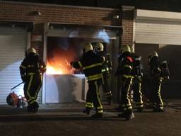 De politie breekt de deuren van de garageboxen open. (Foto: Perry Roovers/SQ Vision)