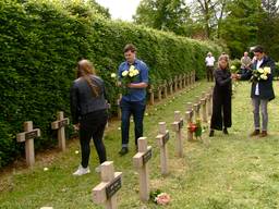 Een witte roos voor elk graf van een slachtoffer van het bombardement