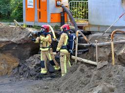 Een brandweer man krijgt ducttape toegeworpen om de gasleiding provisorisch te herstellen. (Foto: Berry van Gaal SQ Mediaproduckties)