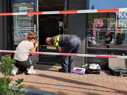 Politie-onderzoek bij de kledingwinkel in Oosterhout na de ramkraak. (Foto: Collin Beijk)
