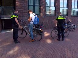De politie deelt boetes uit voor appen (of andere dingen doen op de telefoon) op de fiets.