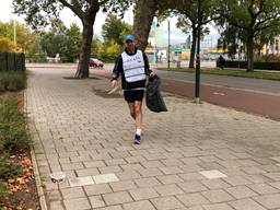 Gewapend met een vuiniszak ruimt Marc Lensen afval op tijdens de Plogging Run. (Foto: Imke van de Laar.)