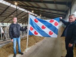 Jan van de Ven en zijn zoon hijsen het bekende blauwwitte vaandel met de rode lelies