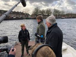 De Koning praat met Max van Zon die afval uit het water haalt met zijn bootje (Foto:Tom van den Oetelaar)