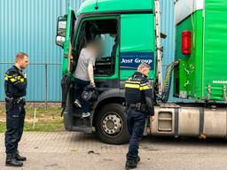 De gewonde trucker pakt zijn spullen uit de cabine. (Foto: Marcel van Dorst/SQ Vision)