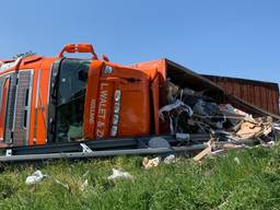 Een vrachtwagen vol huisvuil is gekanteld bij afslag Nuland op de A59 (foto:Bart Meesters/SQVision).