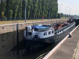 Een boot vaart door de sluis bij Schijndel.