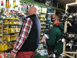Ad van Zon helpt een klant in zijn winkel (Foto: René van Hoof)