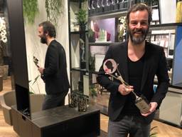 Kapper Arjan Bevers met trofee in zijn lege kapsalon (Foto: Alice van der Plas)