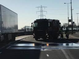 De brandweer spuit de gelekte diesel van het wegdek (foto: Brandweer Berkel-Enschot).