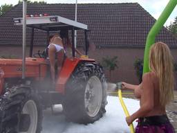 Topless vrouwen wassen tractoren in Loosbroek