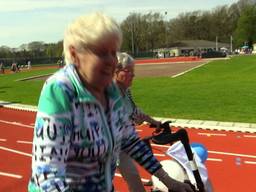 Racende bejaarden scheuren met piepende banden over atletiekbaan