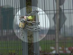 Hekken, sloten en kettingen rond oud papiercontainers gemeente Altena