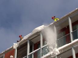 Brandweer haalt gevaarlijk overhangende sneeuw en ijs van dak van winkelcentrum Eindhoven