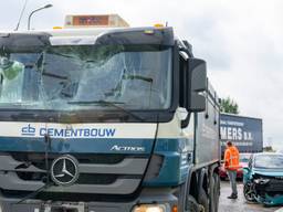 Vrachtwagen rijdt achterop aantal auto's en een busje bij stoplicht