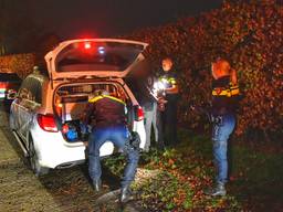 De verdachte wordt in een politiewagen gezet (foto: Rico Vogels/SQ Vision Mediaprodukties).