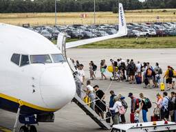 Passagiers in de rij om in te stappen (foto: ANP).