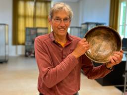 Henk Geurts houdt een replica van de bronsschat vast (foto: Jos Verkuijlen)
