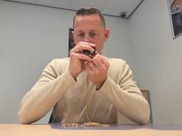 Pjotr Hoogendoorn bekijkt een gouden ketting (foto: Noël van Hooft).