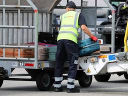 Een medewerker van Skytanking laadt koffers uit het ruim (foto: Collin Beijk).