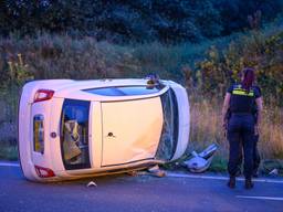 Een agente neemt de gekantelde wagen in Etten-Leur in ogenschouw (foto: Tom van der Put./SQ Vision).