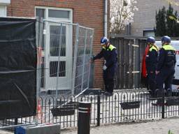 De politie heeft de twee twee-onder-een-kapwoningen afgesloten met een hek.