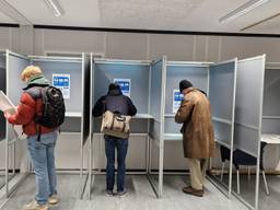 Mensen brengen hun stem uit in een stembureau (foto: Noël van Hooft).