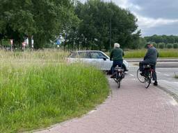 Twee fietsers die vanuit Schijndel komen, willen de rotonde oversteken (Foto: Rochelle Moes).