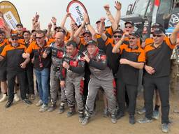 Janus van Kasteren (eerste rij, derde van rechts) viert de zege in de Dakar Rally met zijn team (foto: Ronald Sträter)