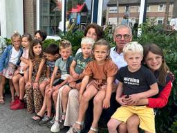 Opa Frans Waalen (69) en oma Maria (66) met hun twaalf kleinkinderen (foto: Jan Peels)