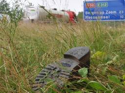 Een verdwaalde schoen in de berm langs de snelweg A58. 