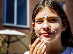 Een meisje smeert zich in met zonnebrandcrème (Foto: ANP). 