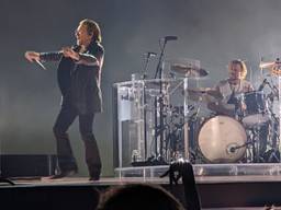 Drummer Bram van den Berg achter U2-frontman Bono (foto: ANP).