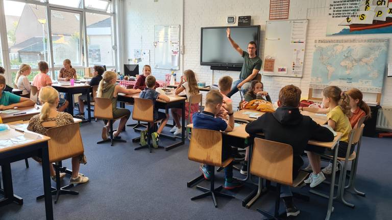 Vrolijk beginnen kinderen aan nieuw schooljaar in gebouw dat minder fris is