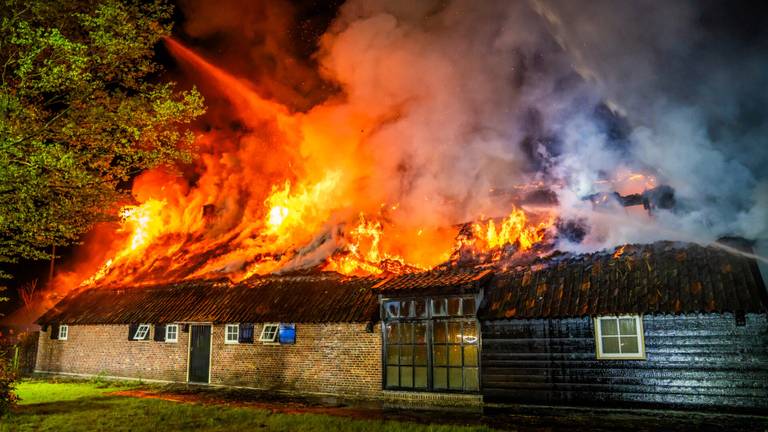 Grote brand verwoest huis met rieten kap, vlammen slaan metershoog uit dak