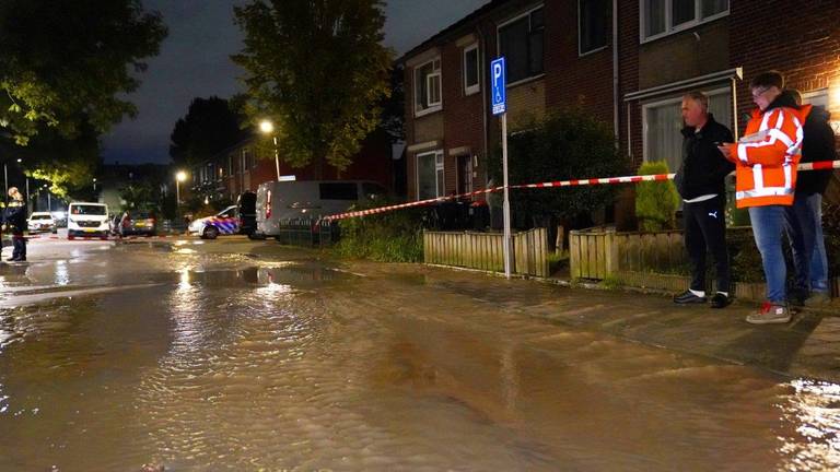 Groot waterlek verandert straat in rivier, auto's dreigen in gat te vallen