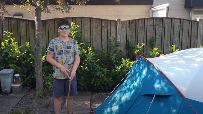 Sem Doomen bij de tent in de achtertuin waar hij samen met zijn zus twee weken in sliep (foto: familie Doomen).