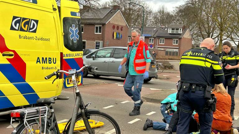 Ambulancemedewerkers en agenten buigen zich over een fietsster die in Veldhoven werd aangereden (foto: Rico Vogels/SQ Vision).