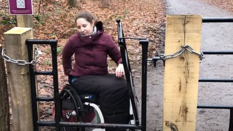 Sylke kan het bos bij Dorst niet meer in door een rolstoelonvriendelijk hek. Foto: Screenshot YouTube