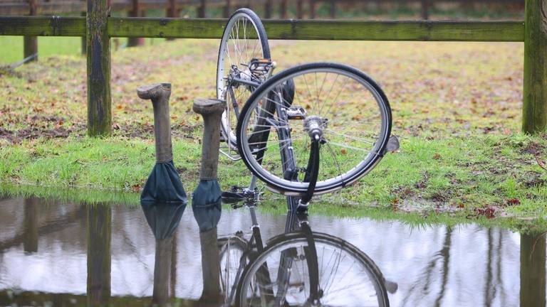 Benen steken uit het water op ondergelopen fietspad, agenten schrikken