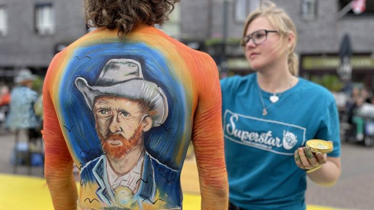 Bodypainter Naomi legt de laatste hand aan haar werk op het lichaam van Sil. (Foto: Alain Heeren)