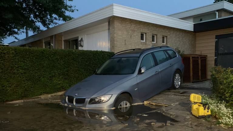 De auto verdween met de voorkant in het gat in de weg in Boxtel (foto: Bart Meesters)