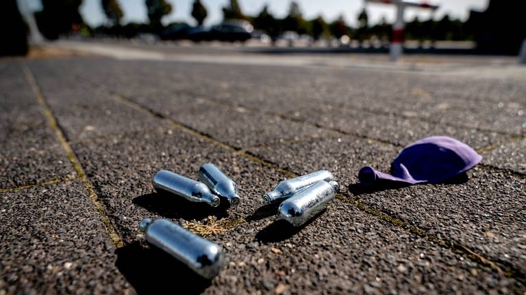 Lachgas patronen en een ballon op een parkeerplaats (Archieffoto: Sander Koning / ANP / Hollandse Hoogte).