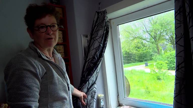 Marjolein de Graaff bij het kapotte raam dat Defensie zou vervangen (foto: Omroep Brabant).