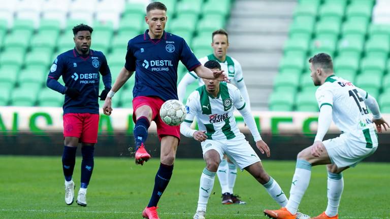 Paul Gladon tussen twee FC Groningens-spelers (foto: OrangePictures).