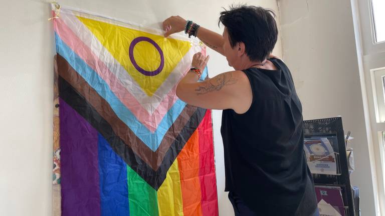 Anne Marie Mulders hangt een regenboog vlag op (foto: René van Hoof). 