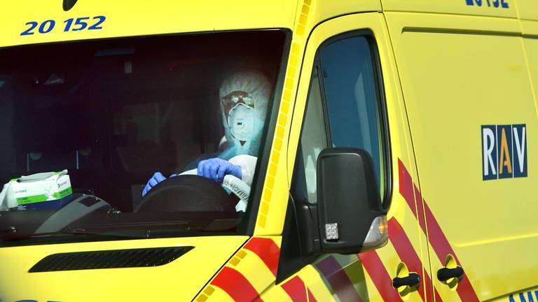 Een ambulancechauffeur in isolatiekleding.