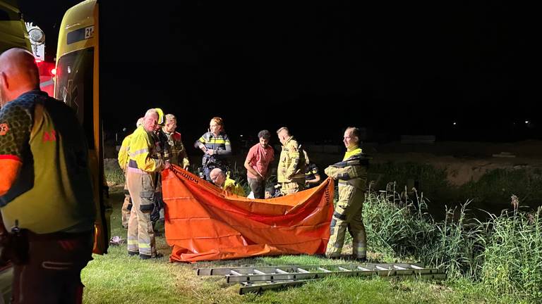 Hulpverleners ontfermen zich over een man die in Sint-Oedenrode vast kwam te zitten in drijfzand (foto: Sander van Gils/SQ Vision).