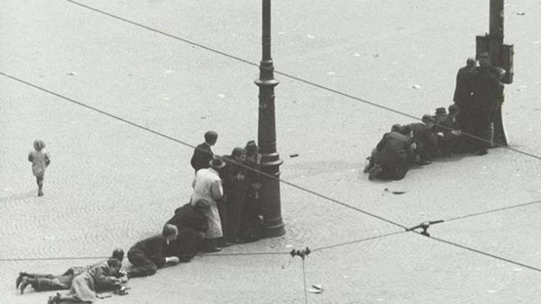 Omstanders zoeken dekking op de Dam (foto: wikipedia)